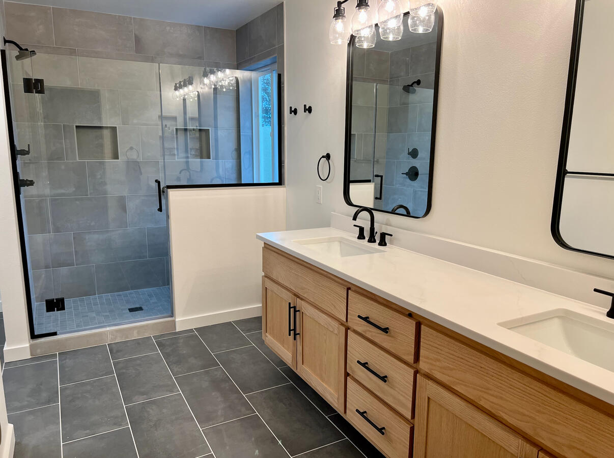 Tile shower with glass door and eight foot oak vanity.